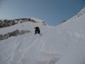 Male mountain climber and extreme skier crosses the bergschrund of a steep north face Royalty Free Stock Photo