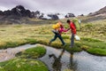 Male mountain climber helps partner cross a river in the Andes of Peru Royalty Free Stock Photo