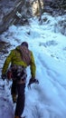 Male mountain guide approaching a steep frozen waterfall after an ice climbing excursion