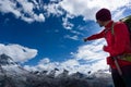 Male mountain guide in red shirt pointing to and explaining the view