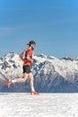 A male mountain runner trains in the snow