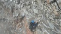 Male mountaineer climbing rocks in the clouds towards mountain summit Hinterer Seelenkogel in Texel group, South Tyrol, Italy