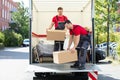 Male Mover Unloading The Cardboard Boxes From Truck Royalty Free Stock Photo