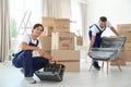 Male movers with instruments and armchair Royalty Free Stock Photo