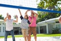 Male Multi Generation Family Playing Volleyball In Garden