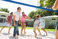 Male Multi Generation Family Playing Volleyball In Garden