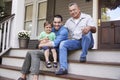 Male Multi Generation Family Sitting On Steps in Front Of House Royalty Free Stock Photo