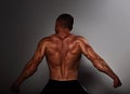 Male muscles strong sportsman flexing his arms with biceps on dark background