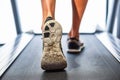 Male muscular feet in sneakers running on the treadmill at the g