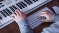 Male musician creates music using computer and keyboard, musician workplace. Royalty Free Stock Photo