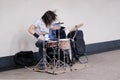 Male musician drummer playing a musical instrument at a public transport station