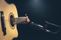 Male musician playing acoustic guitar behind microphone in recording studio. Royalty Free Stock Photo