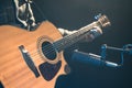 Male musician playing acoustic guitar behind microphone in recording studio. Royalty Free Stock Photo