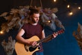 Male musician playing acoustic guitar. Guitarist plays classical guitar on stage in concert Royalty Free Stock Photo