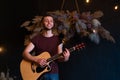 Male musician playing acoustic guitar. Guitarist plays classical guitar on stage in concert Royalty Free Stock Photo