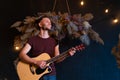 Male musician playing acoustic guitar. Guitarist plays classical guitar on stage in concert Royalty Free Stock Photo