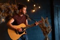 Male musician playing acoustic guitar. Guitarist plays classical guitar on stage in concert Royalty Free Stock Photo