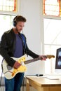 Male musician playing electric guitar in home studio Royalty Free Stock Photo