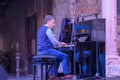 Male musician playing piano outdoors