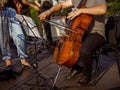 Male musician playing violoncello in orchestra outdoors