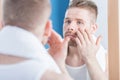 Male narcissus examining complexion