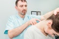 Male neurologist doctor examines cervical vertebrae of female patient spinal column in medical clinic. Neurological physical exami