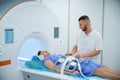 Technologist preparing man for abdominal magnetic resonance imaging procedure