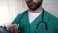 Male nurse asking patient questions, writing answers in form, hospital checklist