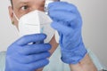 Male nurse with face mask and blue gloves, holding syringe with needle and covid-19 vaccine vial. Medical concept Royalty Free Stock Photo