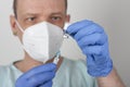 Male nurse with face mask and blue gloves, holding syringe with needle and covid-19 vaccine vial. Medical concept Royalty Free Stock Photo