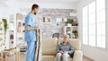 Male nurse helping senior woman getting dressed Royalty Free Stock Photo