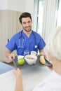 male nurse serving food to senior female patient in clinic Royalty Free Stock Photo