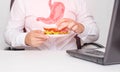 A male office worker holds a sandwich in his hands during lunch. The concept of unhealthy food, snacking, stomach pain. Gastritis Royalty Free Stock Photo