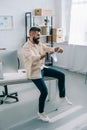 Male office worker tearing papers and sitting