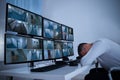 Male Operator Sleeping At Security Monitor's Desk Royalty Free Stock Photo