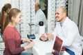 Male ophthalmologist and female patient in modern optics storev