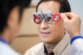 Male ophthalmologist precisely determines diopter for senior man