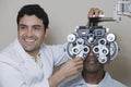 Male Optometrist Adjusting Panels Of Phoropter