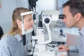 Male optometrist with trial frame checking female patient vision Royalty Free Stock Photo