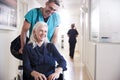 Male Orderly Pushing Senior Female Patient Being Discharged From Hospital In Wheelchair Royalty Free Stock Photo