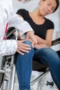 Male orthopedic doctor examining womans knee in clinic Royalty Free Stock Photo