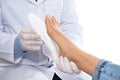 Male orthopedist fitting insole on patient`s foot against background, closeup Royalty Free Stock Photo