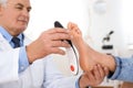 Male orthopedist fitting insole on patient`s foot Royalty Free Stock Photo