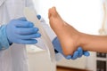 Male orthopedist fitting insole on patient`s foot in clinic Royalty Free Stock Photo