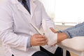 Male orthopedist fitting insole on patient`s foot in clinic Royalty Free Stock Photo