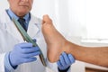 Male orthopedist fitting insole on patient`s foot in clinic Royalty Free Stock Photo