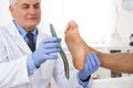 Male orthopedist fitting insole on patient`s foot