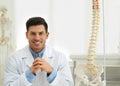 Male orthopedist near human spine model