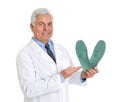 Male orthopedist showing insoles on white