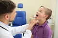 Male otolaryngologist examining little child